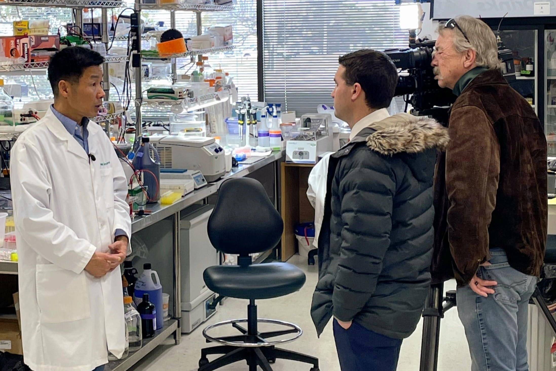 Scientist interviewed in a laboratory setting.